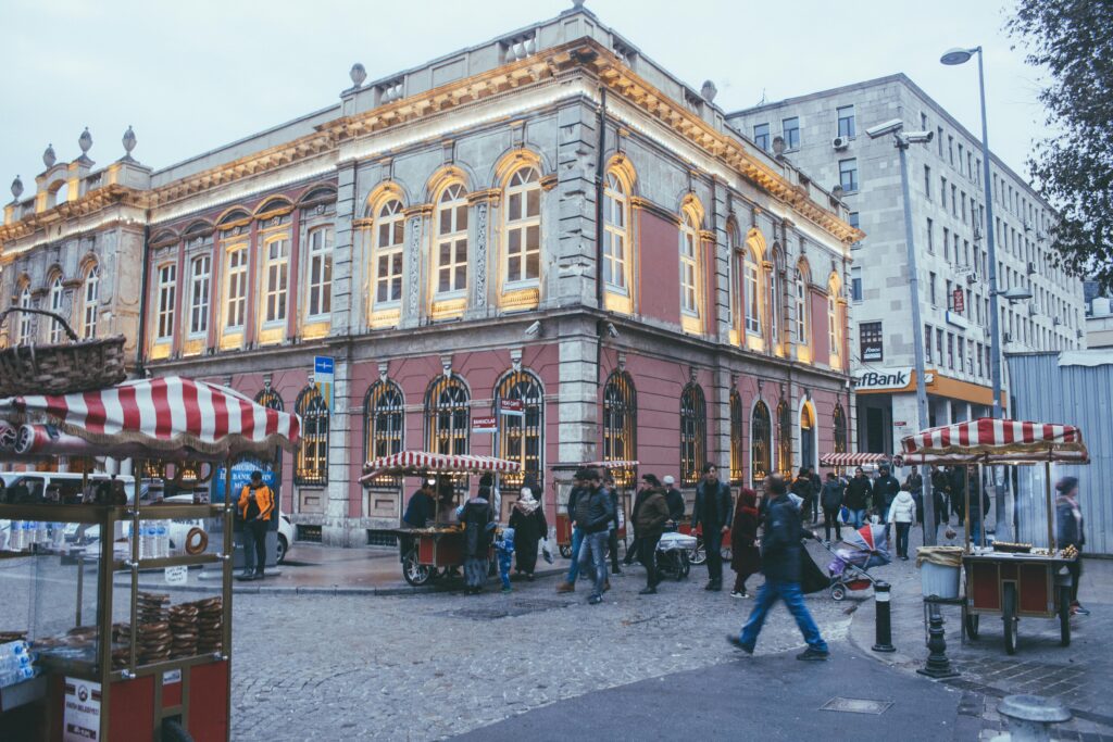 Crowded street scene with historic building and vibrant market stalls, capturing urban life.